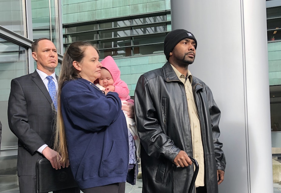 caption: Tyrone Smith, right, describes impact of 2018 racist attack as four defendants are sentenced for a federal hate crime on Jan. 27, 2023. Smith was joined by his fiancée and  the FBI's Rick Collodi, left. 