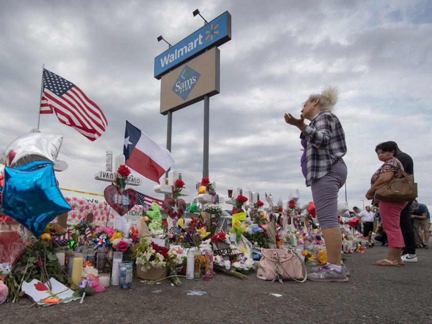 caption: A woman prays at a makeshift memorial for shooting victims at the Cielo Vista Mall Walmart, in El Paso, Texas.