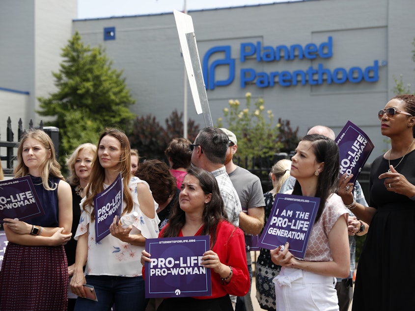 caption: Anti-abortion-rights advocates gather outside a St. Louis Planned Parenthood clinic in June. Title X recipients have been given more time to comply with new regulations.