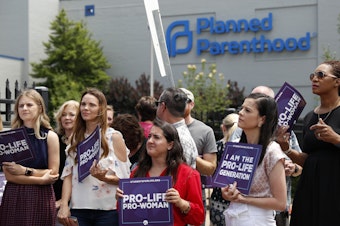 caption: Anti-abortion-rights advocates gather outside a St. Louis Planned Parenthood clinic in June. Title X recipients have been given more time to comply with new regulations.