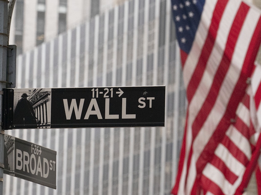 caption: A street sign for Wall Street is seen outside the New York Stock Exchange on Nov. 5, 2020. Stocks rallied after Moderna said its experimental COVID-19 vaccine was nearly 95% effective.