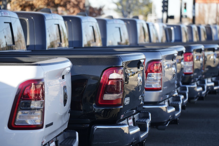 caption: A long line of Ram pickup trucks sits in an otherwise empty storage lot at a Dodge dealership Sunday, Nov. 21, 2021, in Littleton, Colo. 