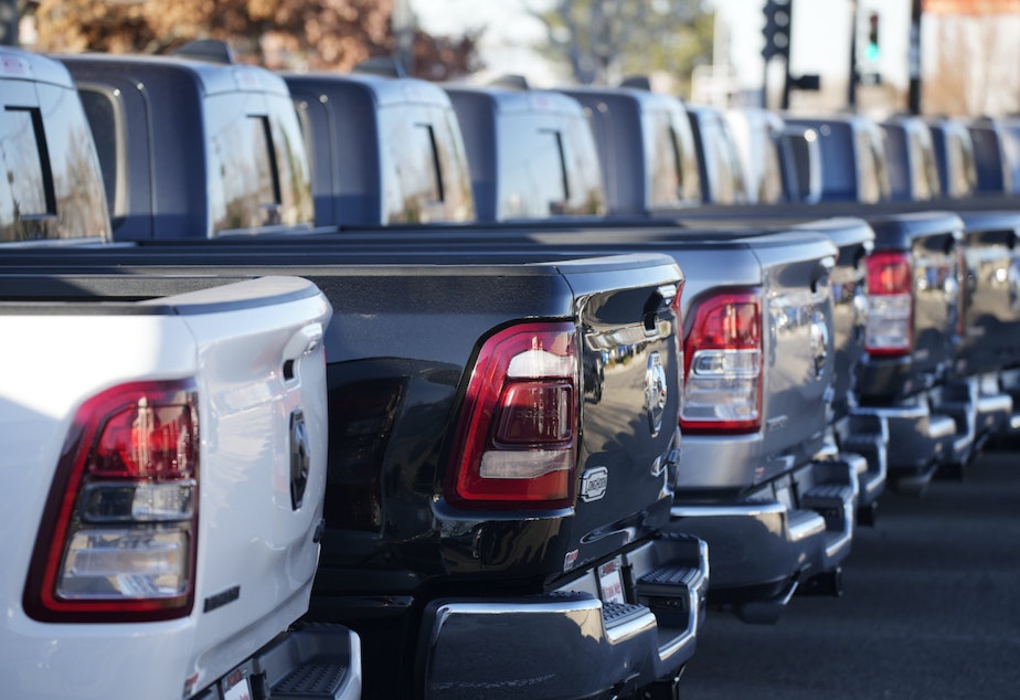 caption: A long line of Ram pickup trucks sits in an otherwise empty storage lot at a Dodge dealership Sunday, Nov. 21, 2021, in Littleton, Colo. 
