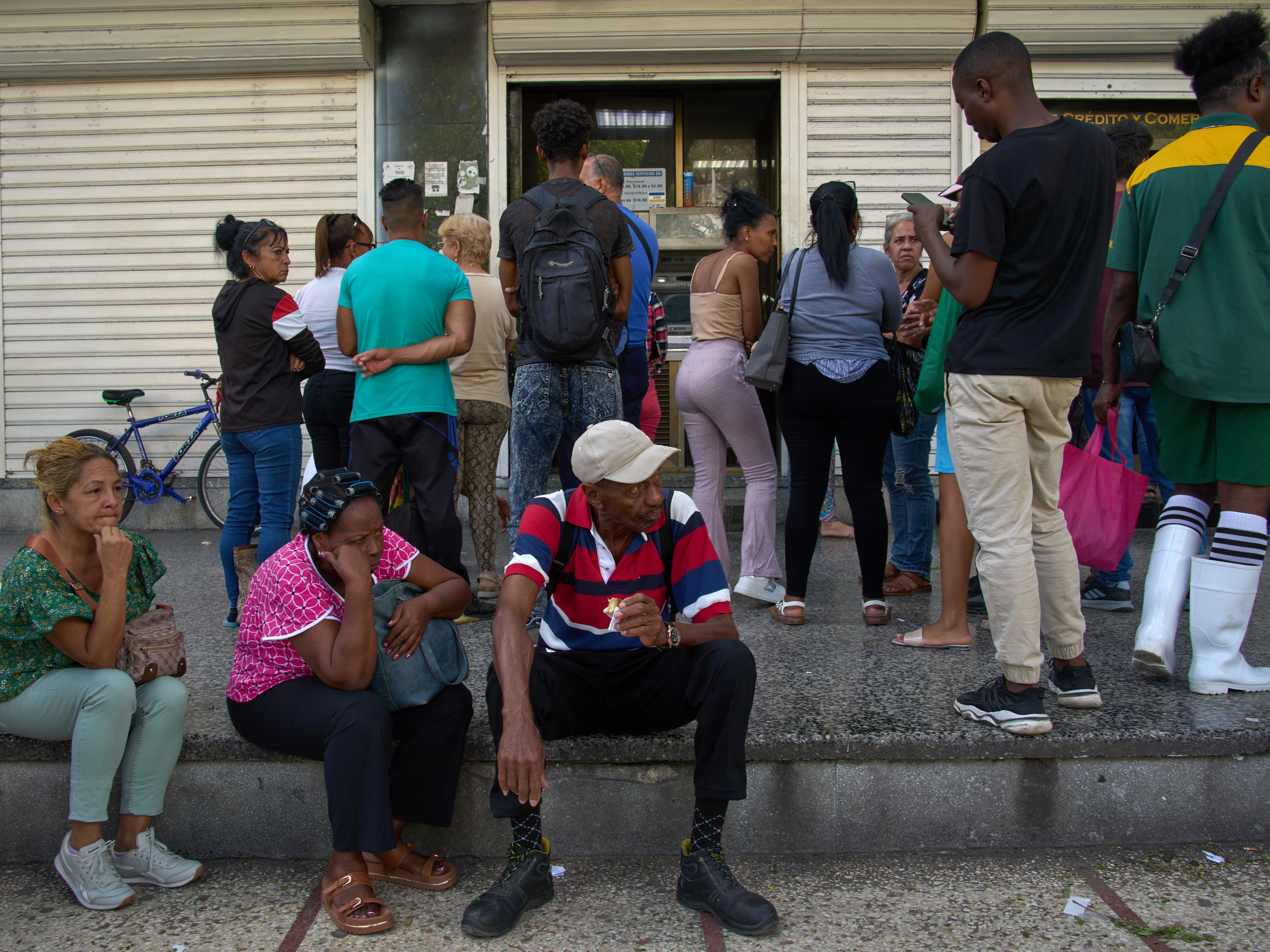 caption: People wait their turn to enter a bank in Havana, Cuba, Wednesday, April 1, 2026.