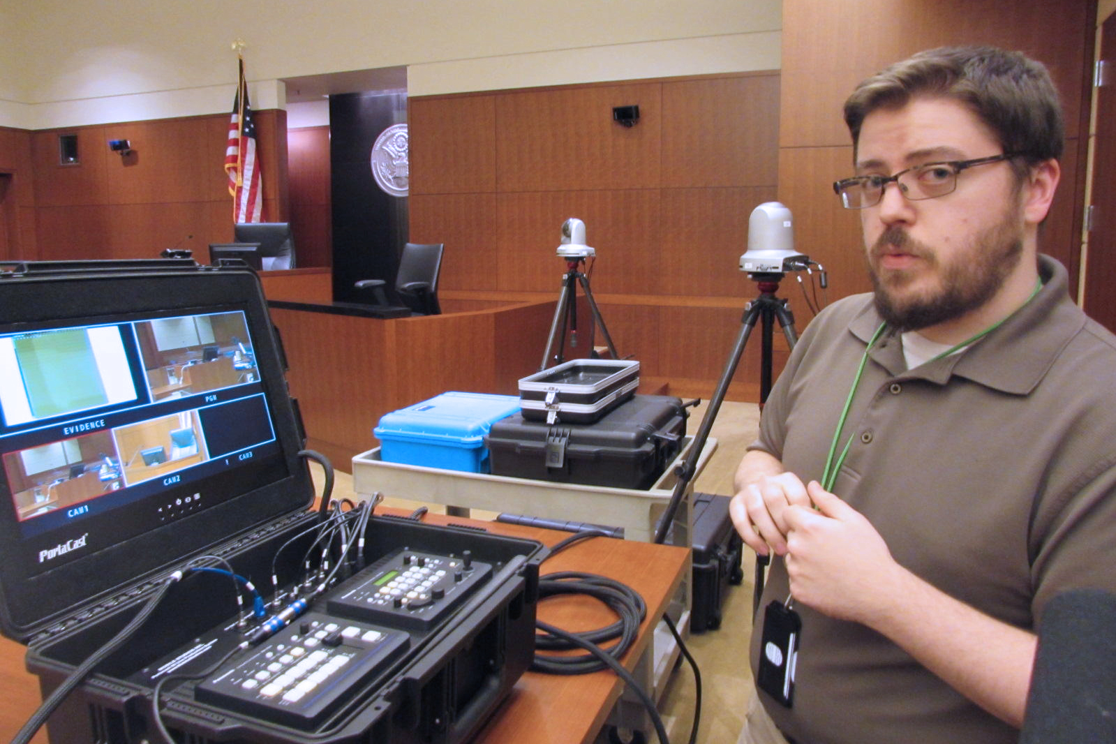 caption: Courtroom technology administrator Jeremy Sites explains the camera setup in U.S. District Court. 