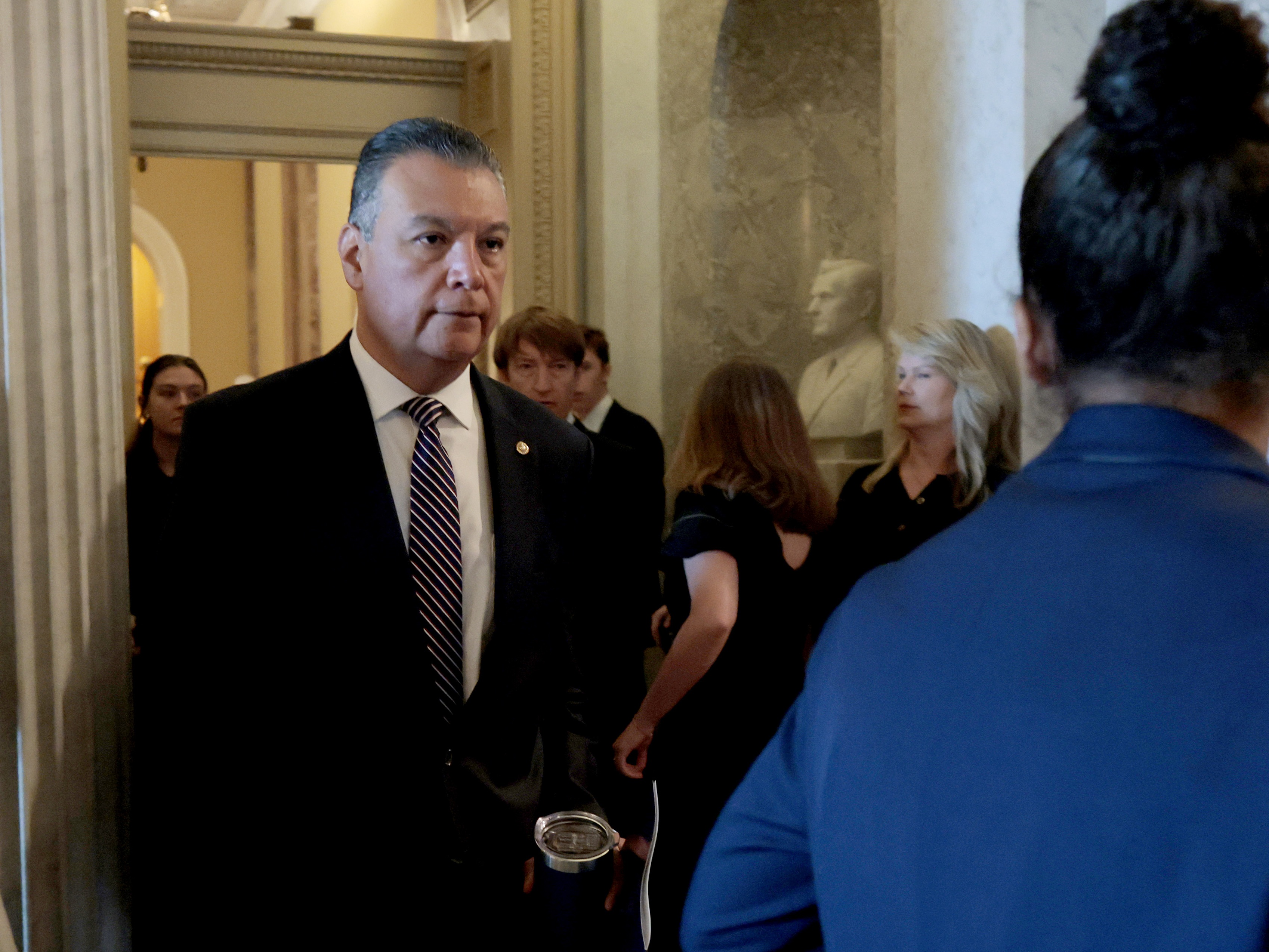 caption: Sen. Alex Padilla, D-Calif., walks to the Senate chambers on Tuesday to deliver his first remarks on the Senate floor since he was forcefully removed from a DHS press conference last week.