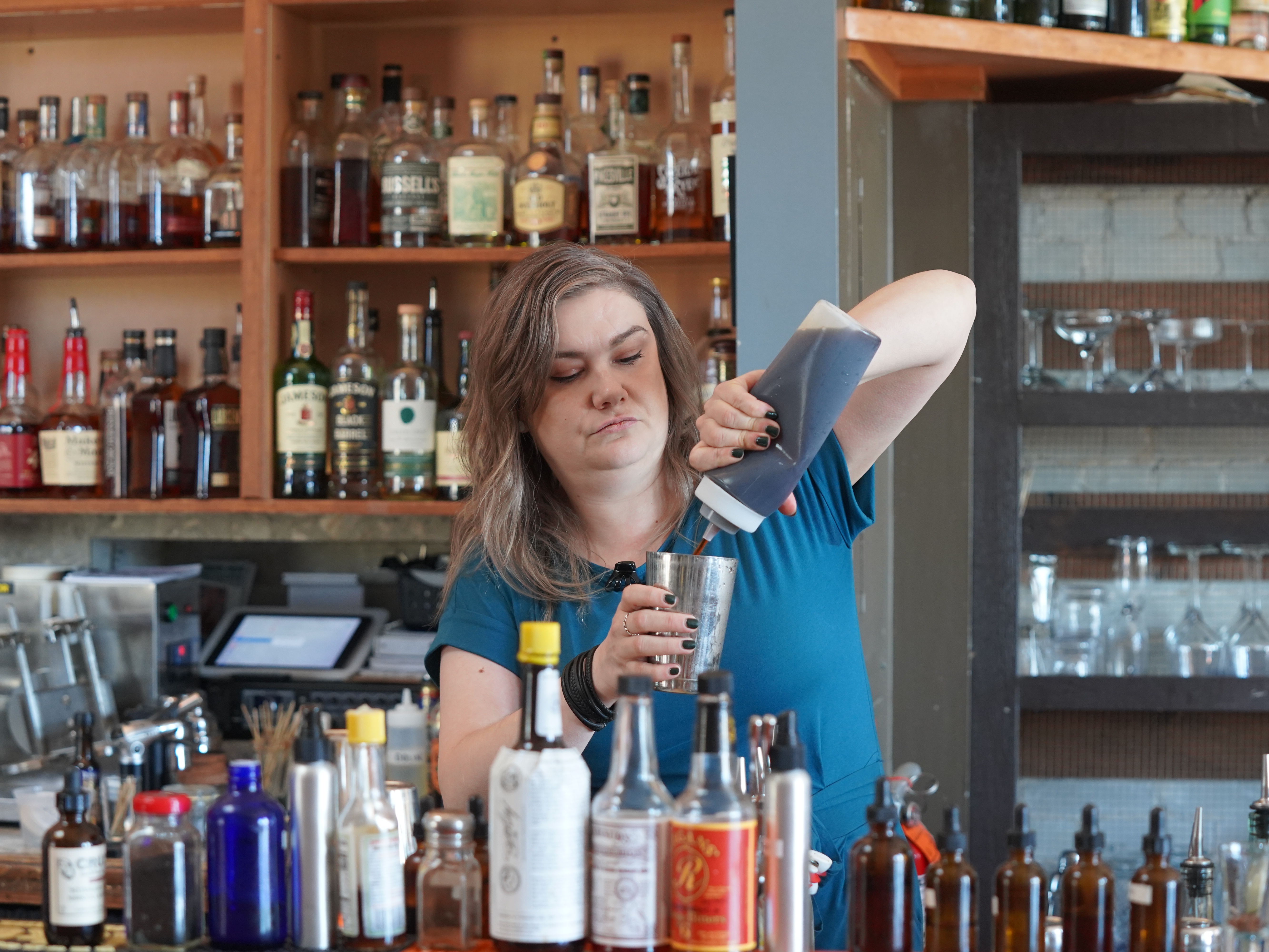 caption: Kala Brooks is the bar manager of Top of the Monk, a craft cocktail bar in downtown Asheville. She hopes fall tourists will help boost business.