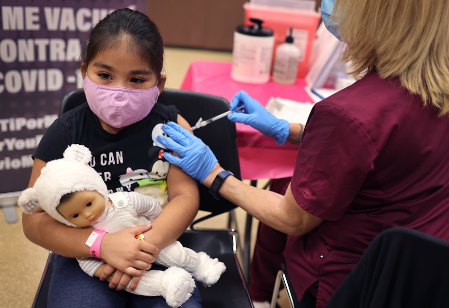 caption: First grader Rihanna Chihuaque, 7, receives a COVID-19 vaccine at Arturo Velasquez Institute in Chicago last November.