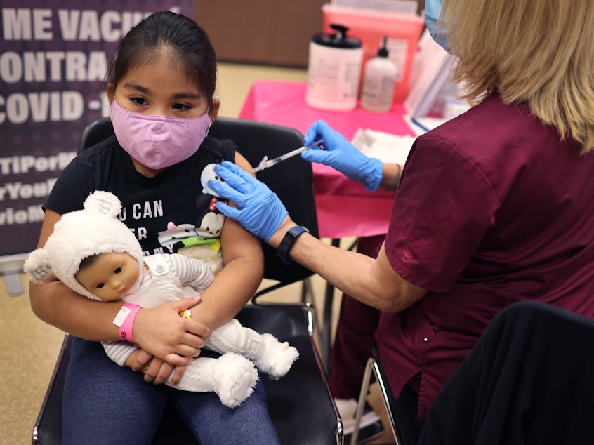 caption: First grader Rihanna Chihuaque, 7, receives a COVID-19 vaccine at Arturo Velasquez Institute in Chicago last November.