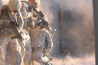 caption: Officers of 1st Stryker Brigade Combat Team, 'Ready First' 1st Armored Division, participate in an urban combat exercise at a training facility on Fort Bliss, Texas in 2011.