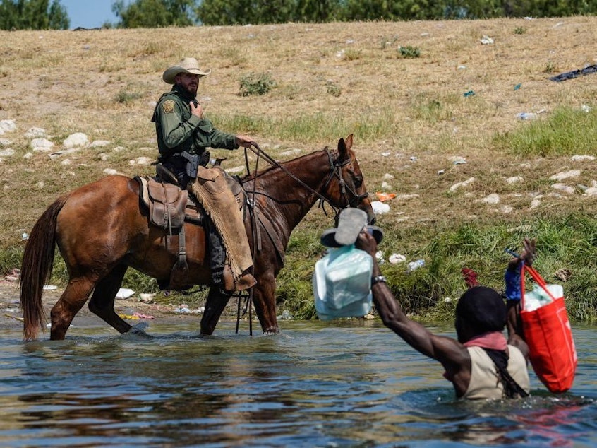 caption: A United States Border Patrol agent on horseback tries to stop a Haitian migrant from entering in Del Rio, Texas. The Department of Homeland Security pledged an investigation into the incident.