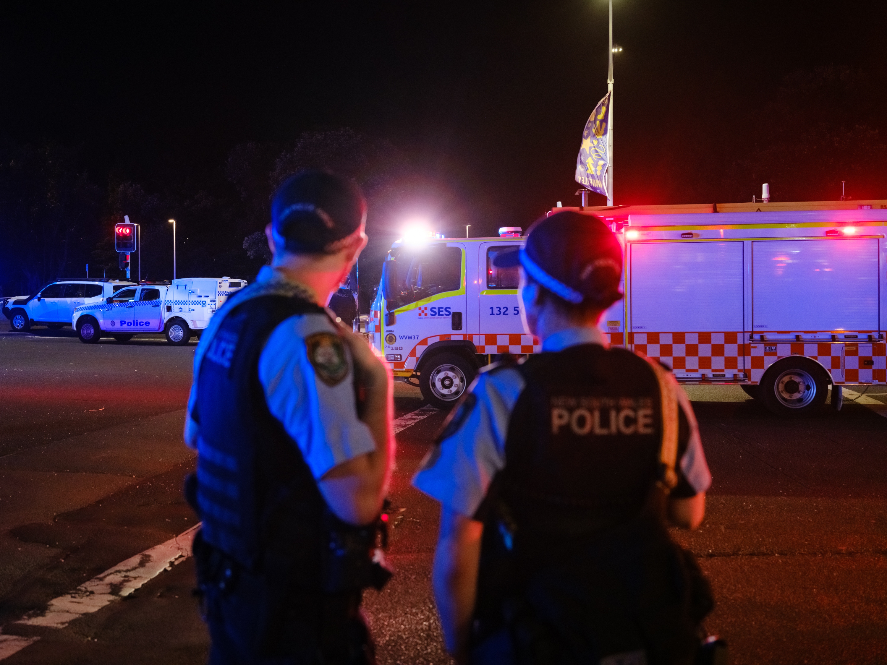 caption: Police set up a cordon line at the scene of a mass shooting at Bondi Beach on Sunday in Sydney, Australia.
