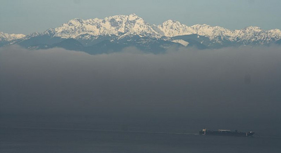 caption: A Washington state ferry moves through the fog. 