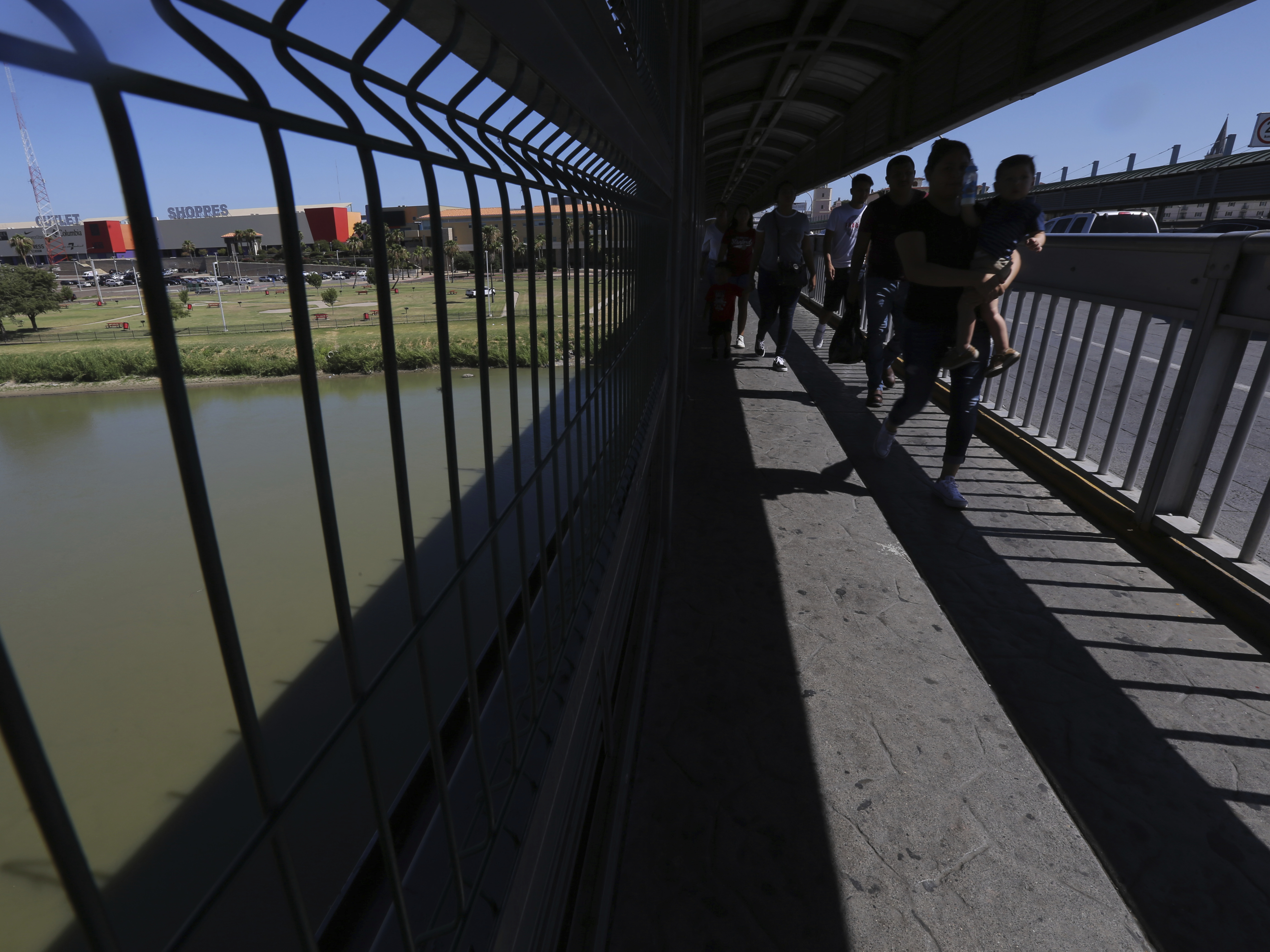 caption: People walk across International Bridge 1 Las Americas, a legal port of entry which connects Laredo, Texas in the U.S. with Nuevo Laredo, Mexico.