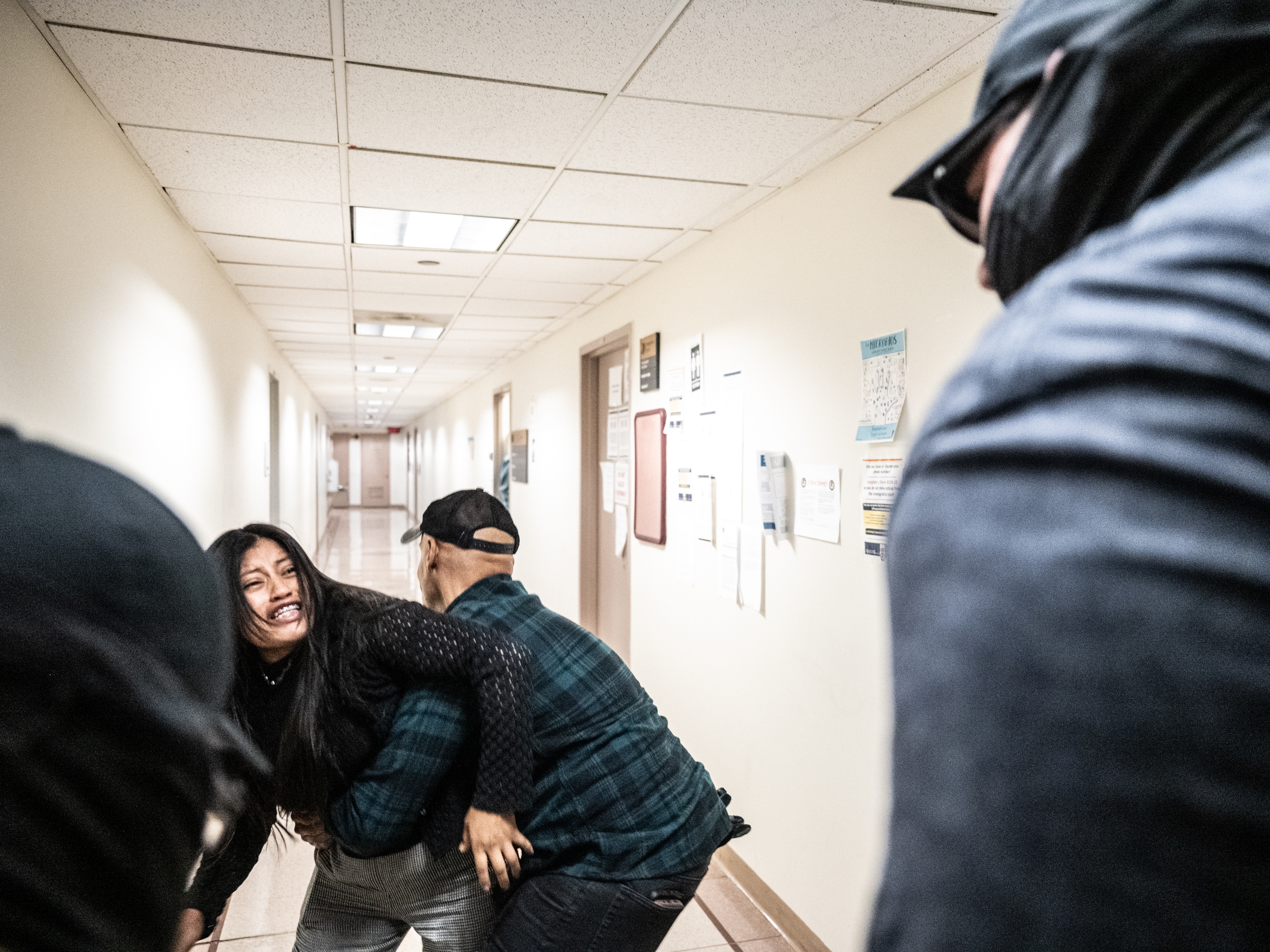 caption: A federal agent restrains the wife of a detained man from Ecuador on Sept. 25 in New York City. The agent was later placed on leave.