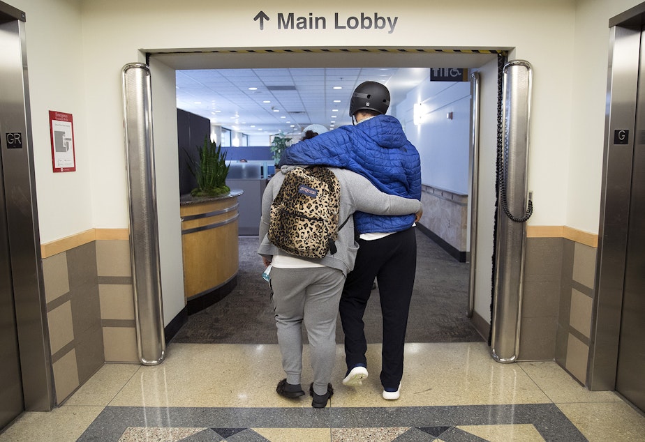 caption: Da'Nesha Mitchell, 24, walks with her arm around her brother, DaShawn Horne, after a physical therapy appointment on Wednesday, June 13, 2018, at Harborview Medical Center in Seattle. 