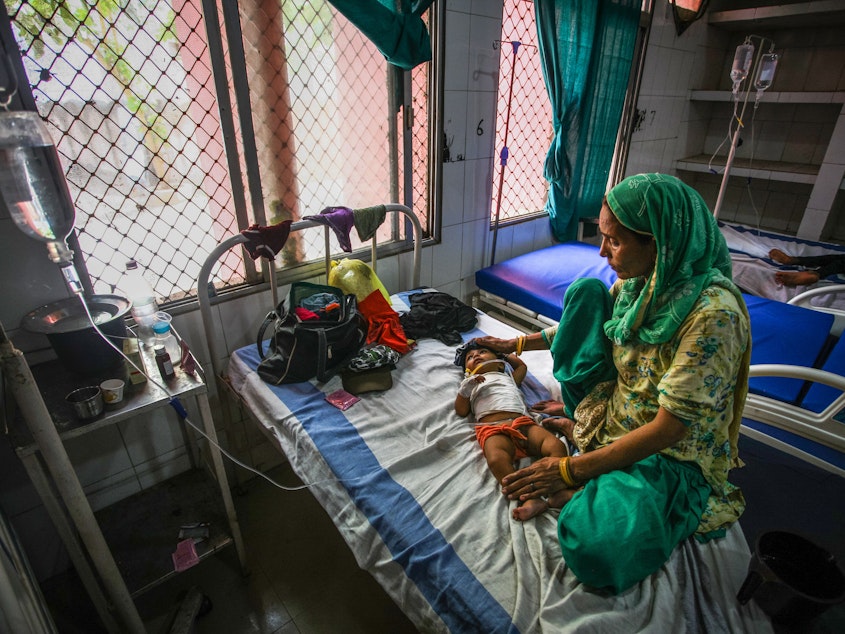 caption: A 7-month-old child with diarrhea lies in a bed at a hospital in India. Oral rehydration salts are a cheap and effective treatment but are underused. A new study aims to find out why.