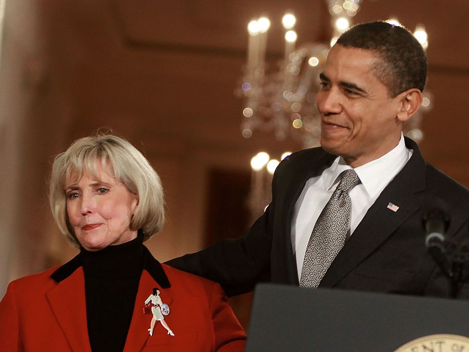 caption: President Barack Obama stands with Lilly Ledbetter before signing the Lilly Ledbetter Fair Pay Act during an event in the East Room of the White House on Jan. 29, 2009.