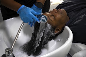 caption: Nina Trapp washes DaVonna Johnson’s hair during an appointment at Mati’s Salon and Barbershop on Friday, May 24, 2024, along Rainier Avenue South in Seattle.