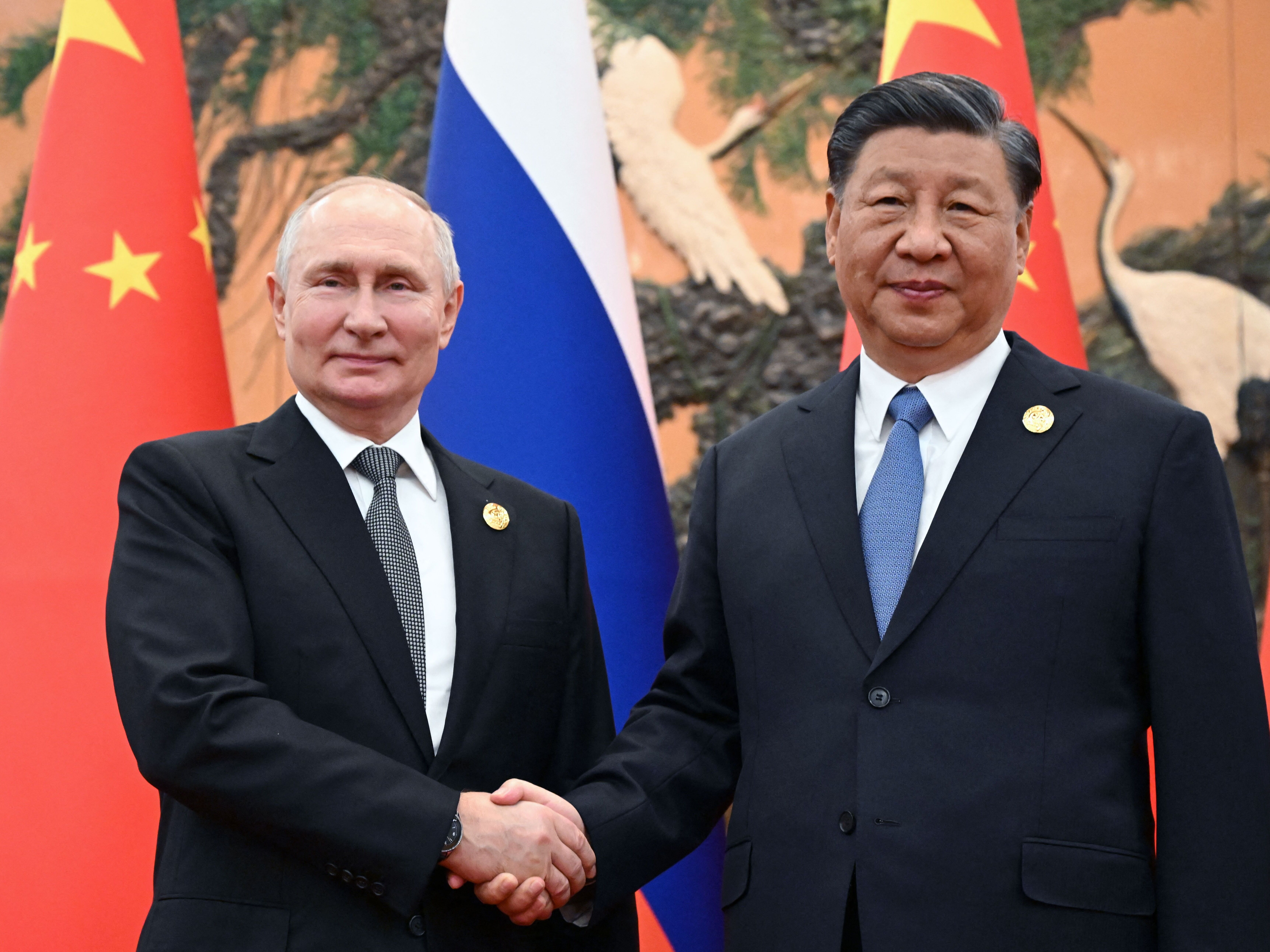 caption: Russian President Vladimir Putin and Chinese President Xi Jinping shake hands during a meeting in Beijing on Oct. 18, 2023. 
