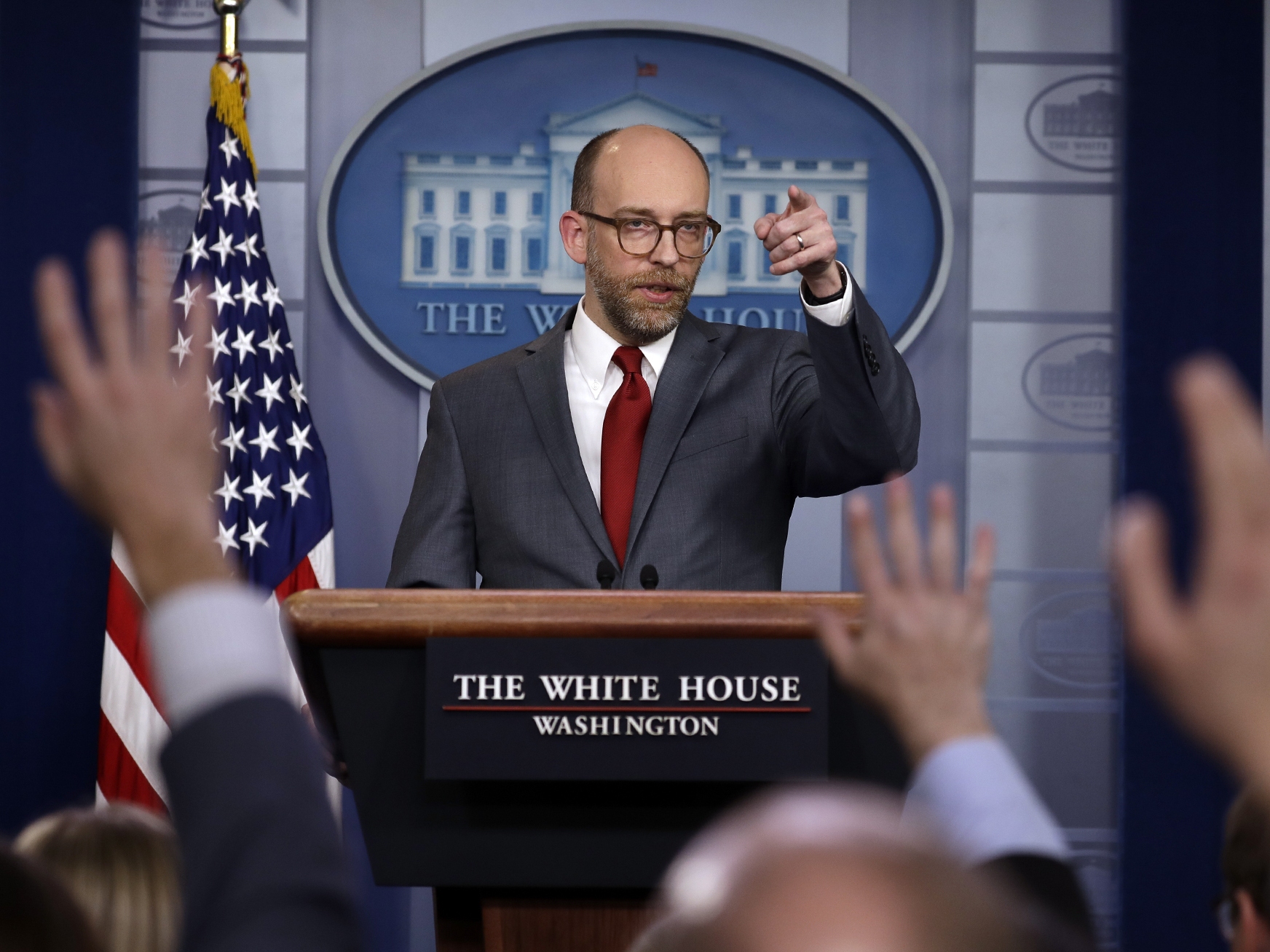 caption: Russ Vought, director of the White House Office of Management and Budget, speaks at a press briefing during President Trump's first term, in 2019.