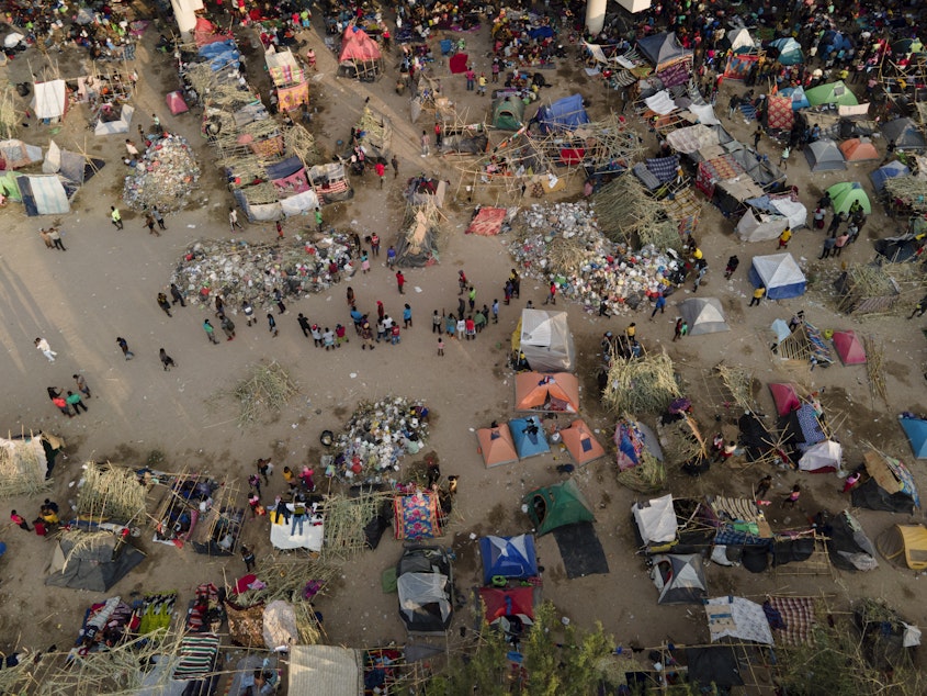 caption: Migrants, many from Haiti, are seen at an encampment along the Del Rio International Bridge near the Rio Grande on Tuesday.