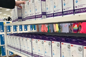 caption: A woman reaches for a box of N95 masks at a Target in West Seattle. Reporter Ann Dornfeld took this photo on Friday, March 20, when she was at Target to buy toilet paper. Dornfeld said she was disturbed that Target was selling masks while they were being rationed at hospitals.