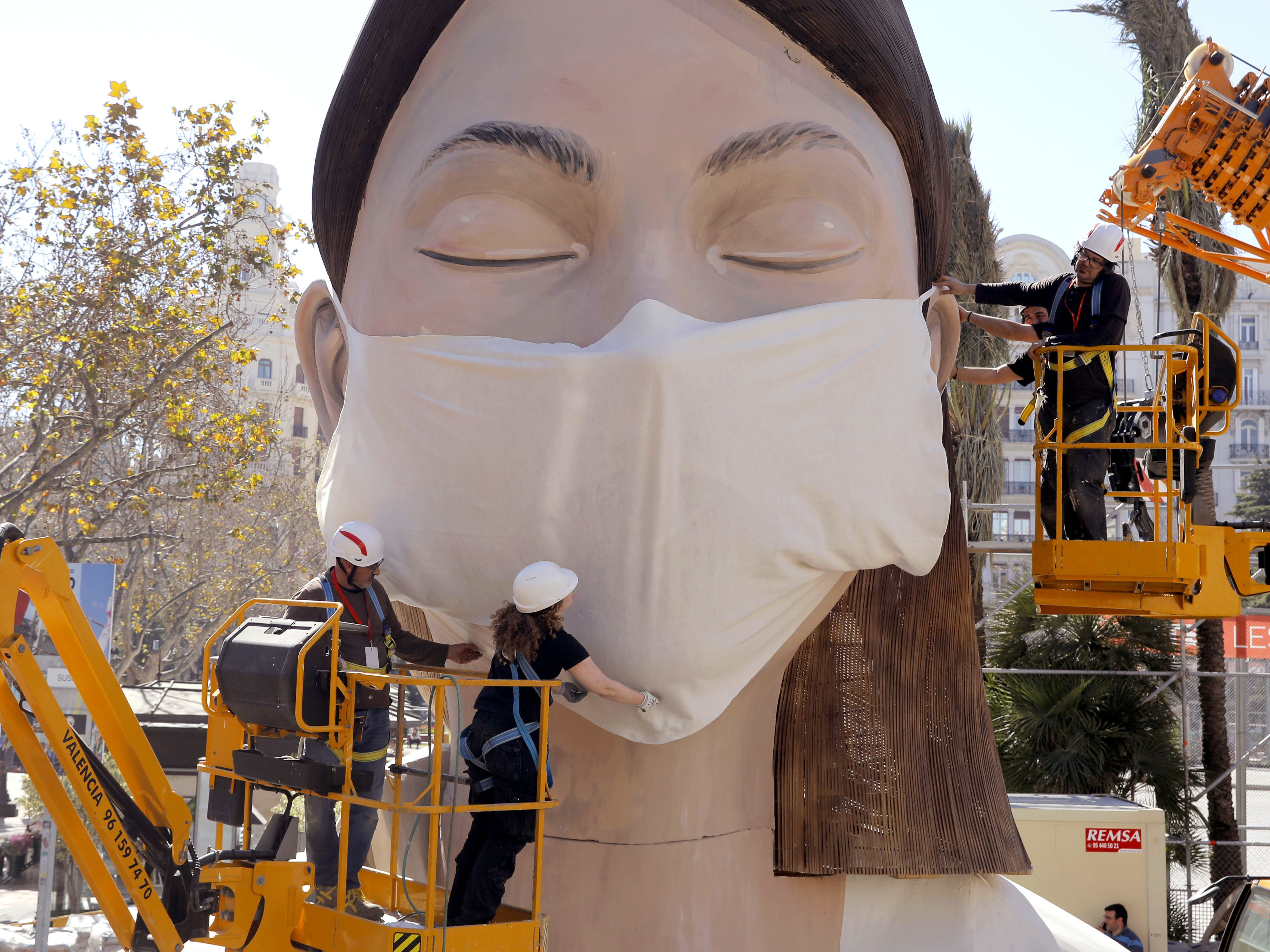 caption: The World Health Organization called the COVID-19 viral disease a pandemic Wednesday. Here, workers in Spain place a medical mask on a figure that was to be part of the Fallas festival in Valencia. The festival has been canceled over the coronavirus outbreak.