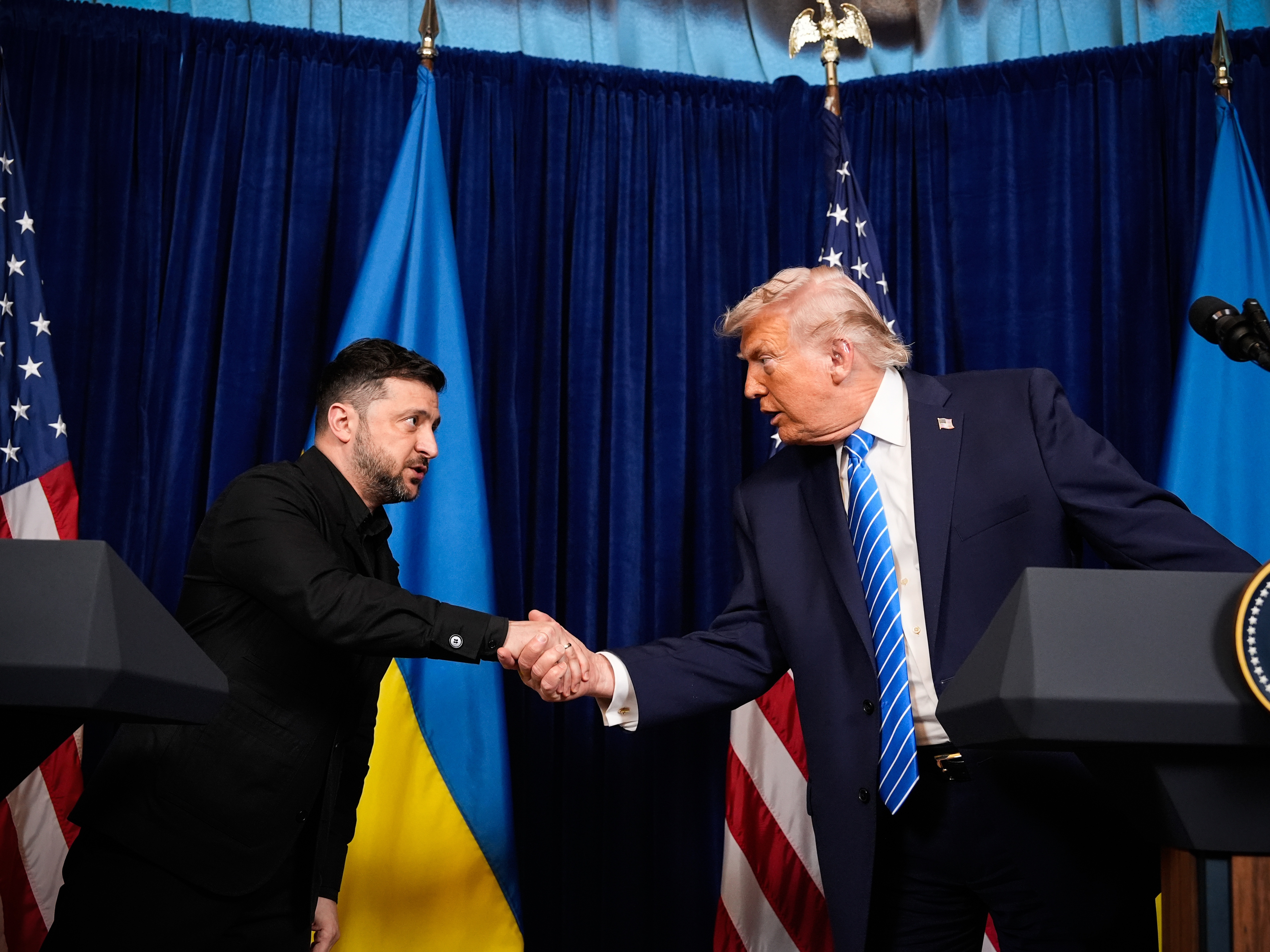 caption: President Trump and Ukrainian President Volodymyr Zelenskyy shake hands at the start of a joint news conference following a meeting at Trump's Mar-a-Lago club, in Palm Beach, Fla., Sunday.