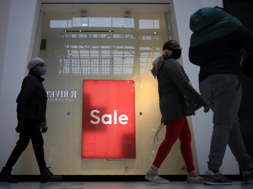 caption: Shoppers walk past a "Sale" sign outside a store at the Easton Town Center Mall in Columbus, Ohio, on Jan. 7.