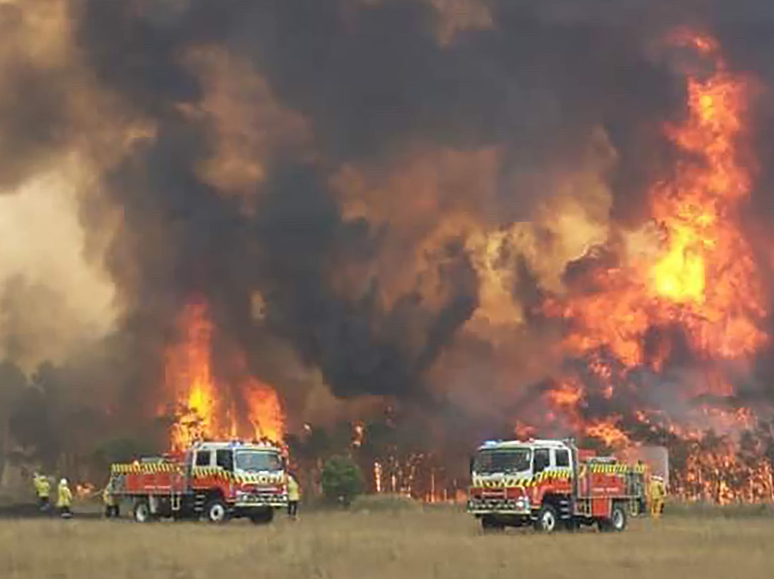 caption: Wildfires burning across Australia's two most-populous states Tuesday trapped residents of a seaside town in apocalyptic conditions, destroyed properties and caused fatalities.