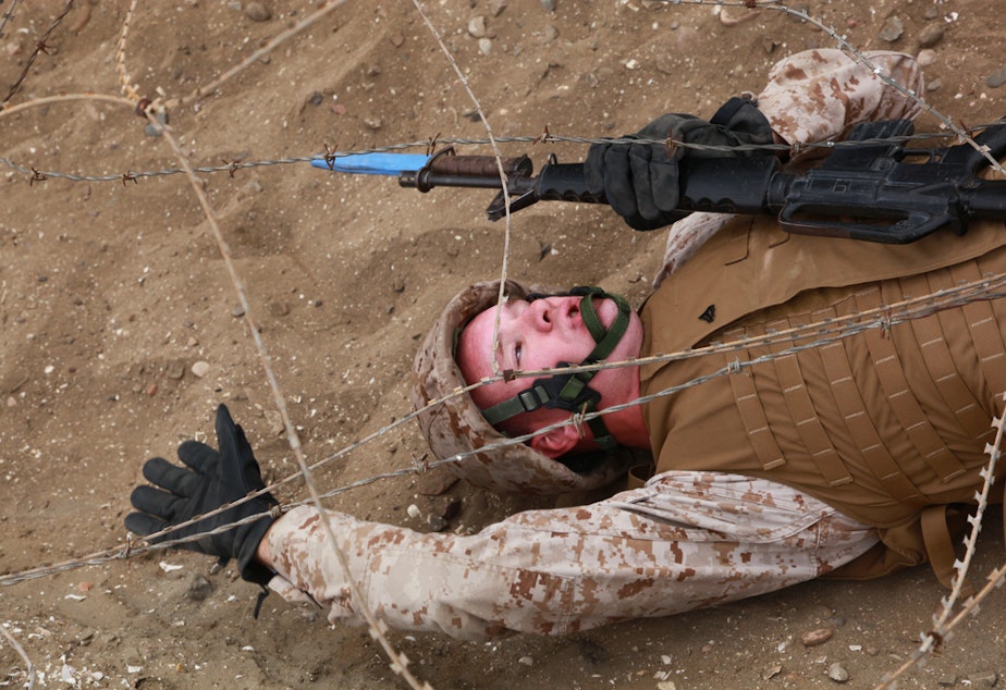 caption: A U.S. Marine, with Headquarters and Headquarters Squadron, navigates under constantina wire during a bayonet course training evolution aboard Marine Corps Recruit Depot, San Diego, Calif., June 1, 2012.