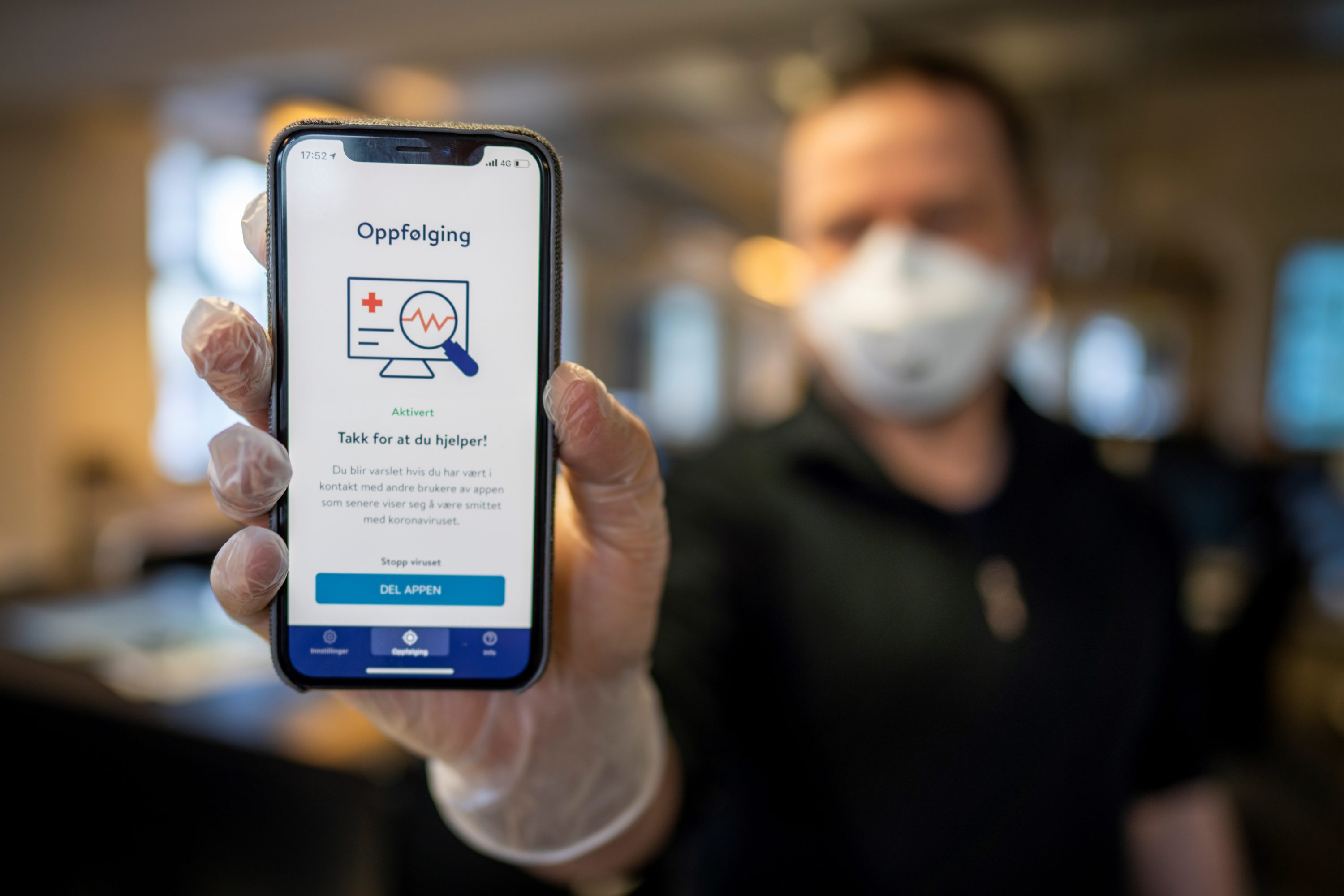caption: A man holds a smartphone showing a tracking and tracing app launched by the National Institute of Public Health to try to halt a return of the new coronavirus, on April 17, 2020 in Oslo. (Heiko Junge /NTB Scanpix/AFP via Getty Images)