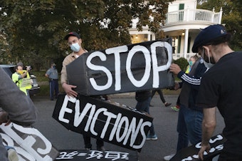 caption: Housing activists erect a sign in front of Massachusetts Gov. Charlie Baker's house in Swampscott, Mass., on Oct. 14, 2020. The Centers for Disease Control and Prevention has extended a moratorium on evictions until the end of July.