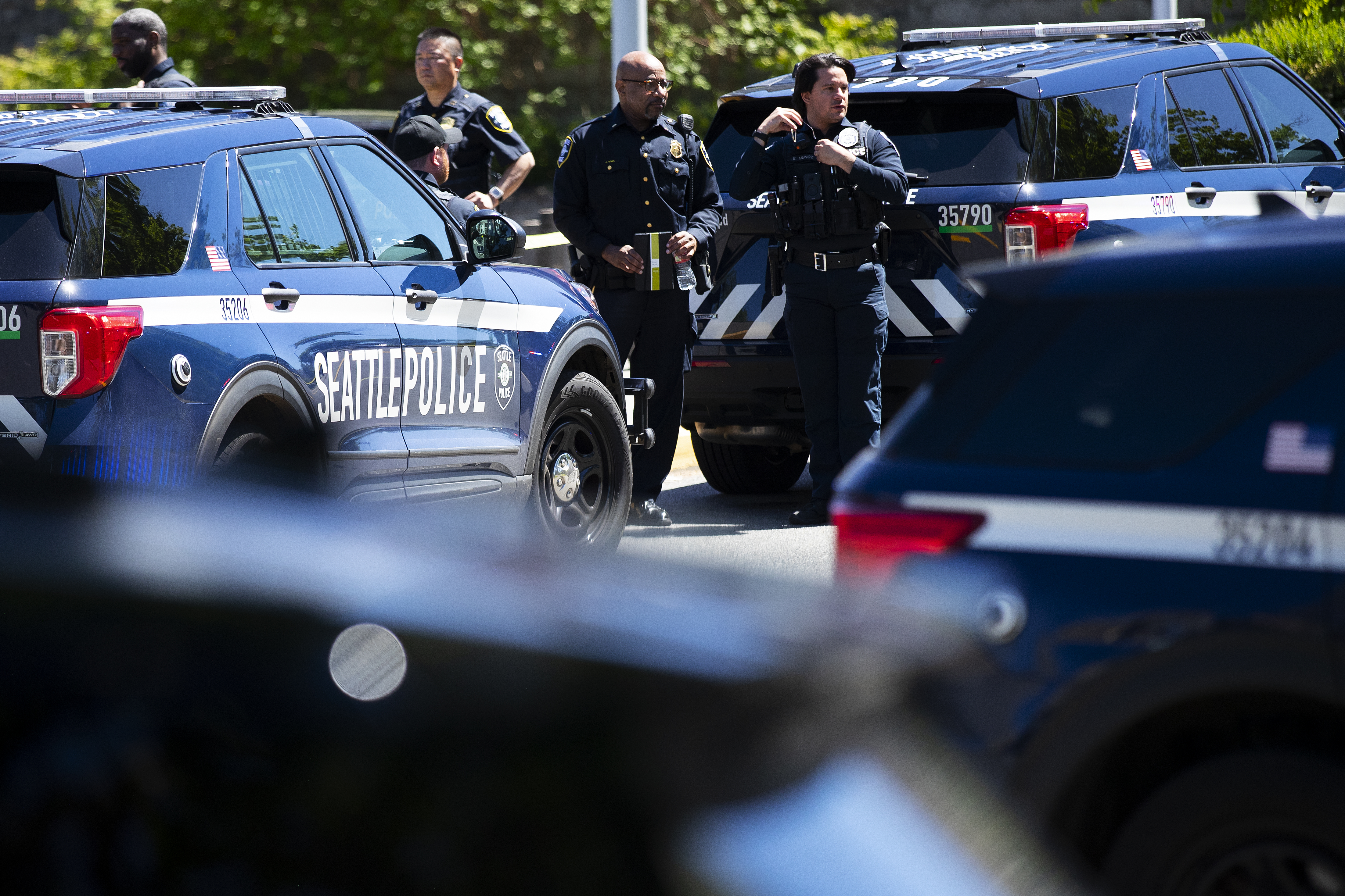 caption: Seattle police officers gather in the parking lot of Garfield High School following a shooting on Thursday, June 6, 2024, in Seattle. 
