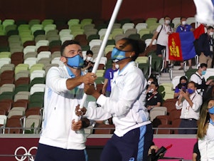 caption: Uruguay flag bearers Deborah Rodriguez and Bruno Cetraro Berriolo lead their team out during the opening ceremony of the Tokyo 2020 Olympic Games at Olympic Stadium.