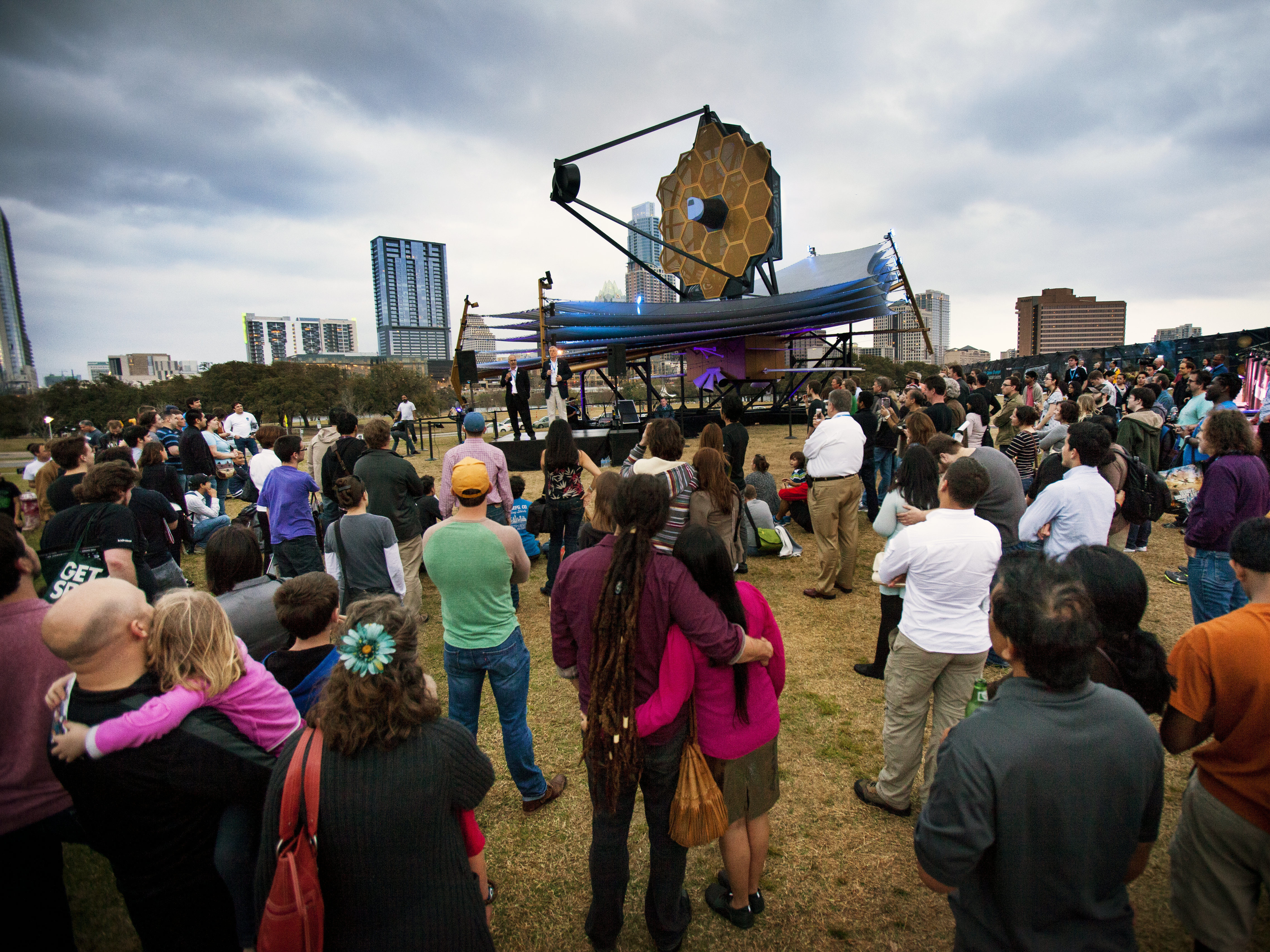 caption: A crowd gathers as Nobel Laureate John Mather and Northrop Grumman engineer Scott Willoughby speak in front a model of NASA's James Webb Space Telescope at South by Southwest on March 9, 2013.