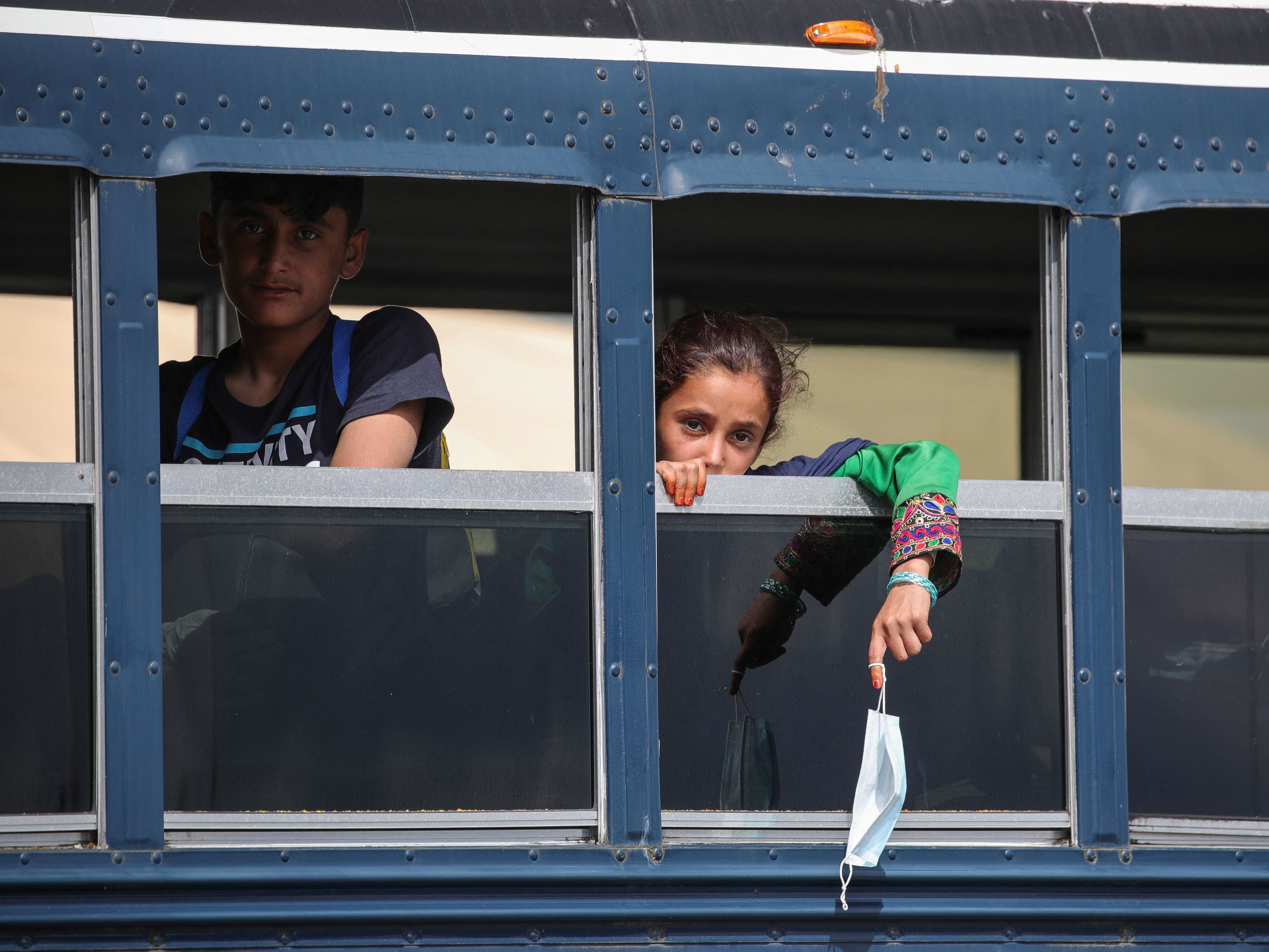 caption: Afghan evacuees sit on a bus at the U.S. air base in Ramstein, Germany, on Aug. 26. Ramstein Air Base, the largest U.S. Air Force base in Europe, has hosted thousands of Afghans.