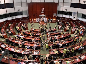 caption: Protesters flooded into Hong Kong's parliament chamber after breaking into the government's headquarters on Monday — the 22nd anniversary of the city's handover from Britain to China.