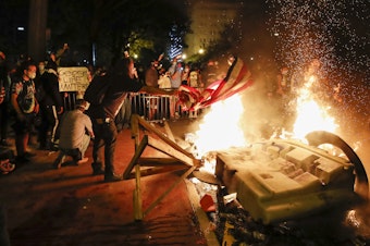 caption: Demonstrators start a fire on Sunday near the White House as they protest the death of George Floyd.
