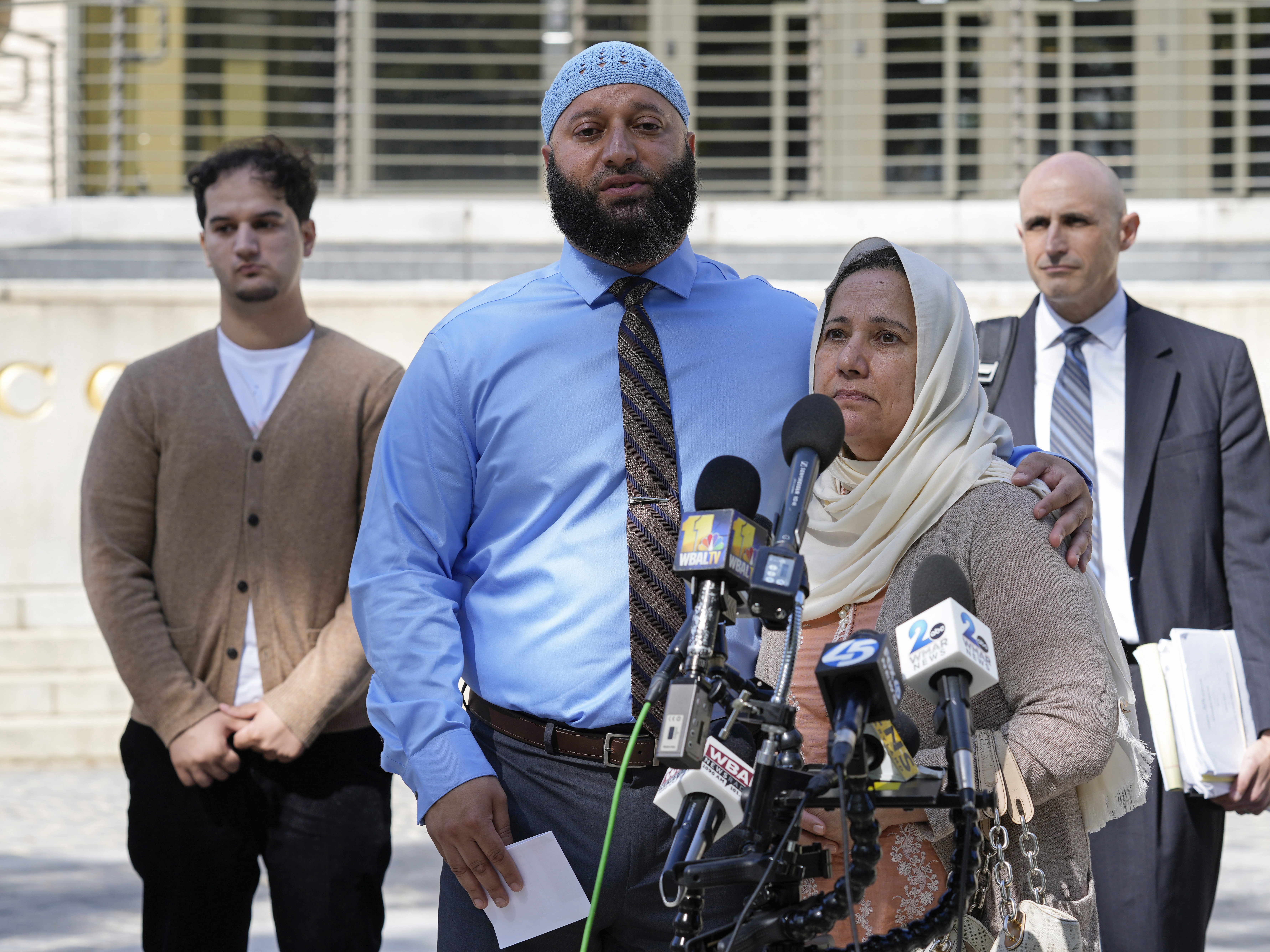 caption: Adnan Syed, standing with his mother Shamim Rahman, talks with reporters outside Maryland's Supreme Court in Annapolis, Md., on Oct. 5, 2023.