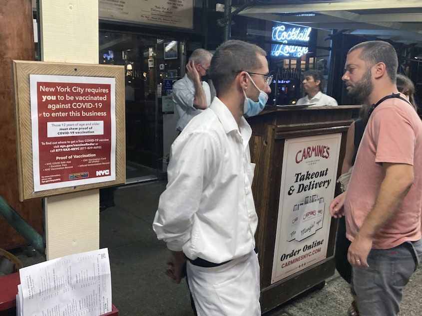 caption: A sign informs customers they must show proof of vaccination against COVID-19 to dine indoors at Carmine's Italian restaurant in Manhattan in August.