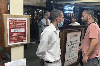 caption: A sign informs customers they must show proof of vaccination against COVID-19 to dine indoors at Carmine's Italian restaurant in Manhattan in August.