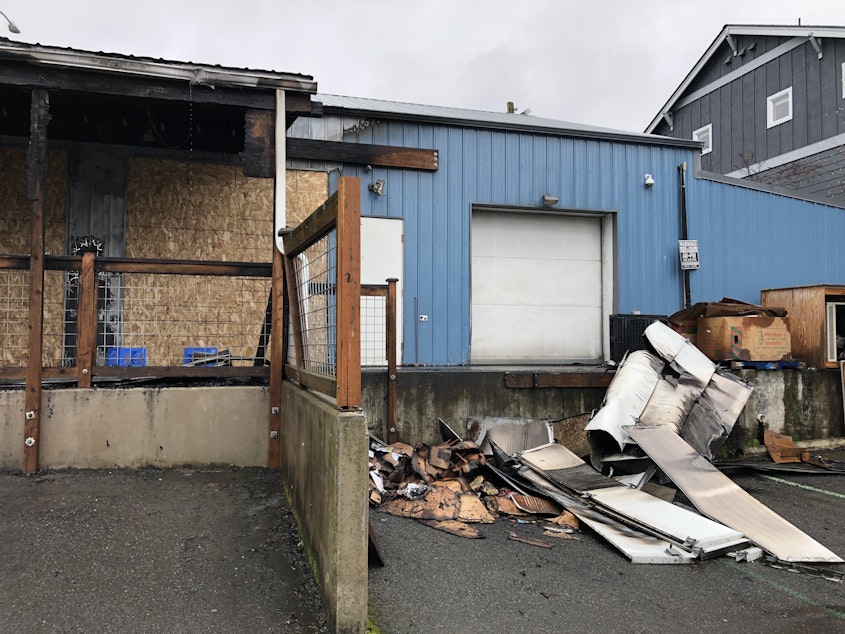 caption: Burnt cardboards and other debris line the loading dock of Rising Sun Produce in Seattle's Roosevelt neighborhood.