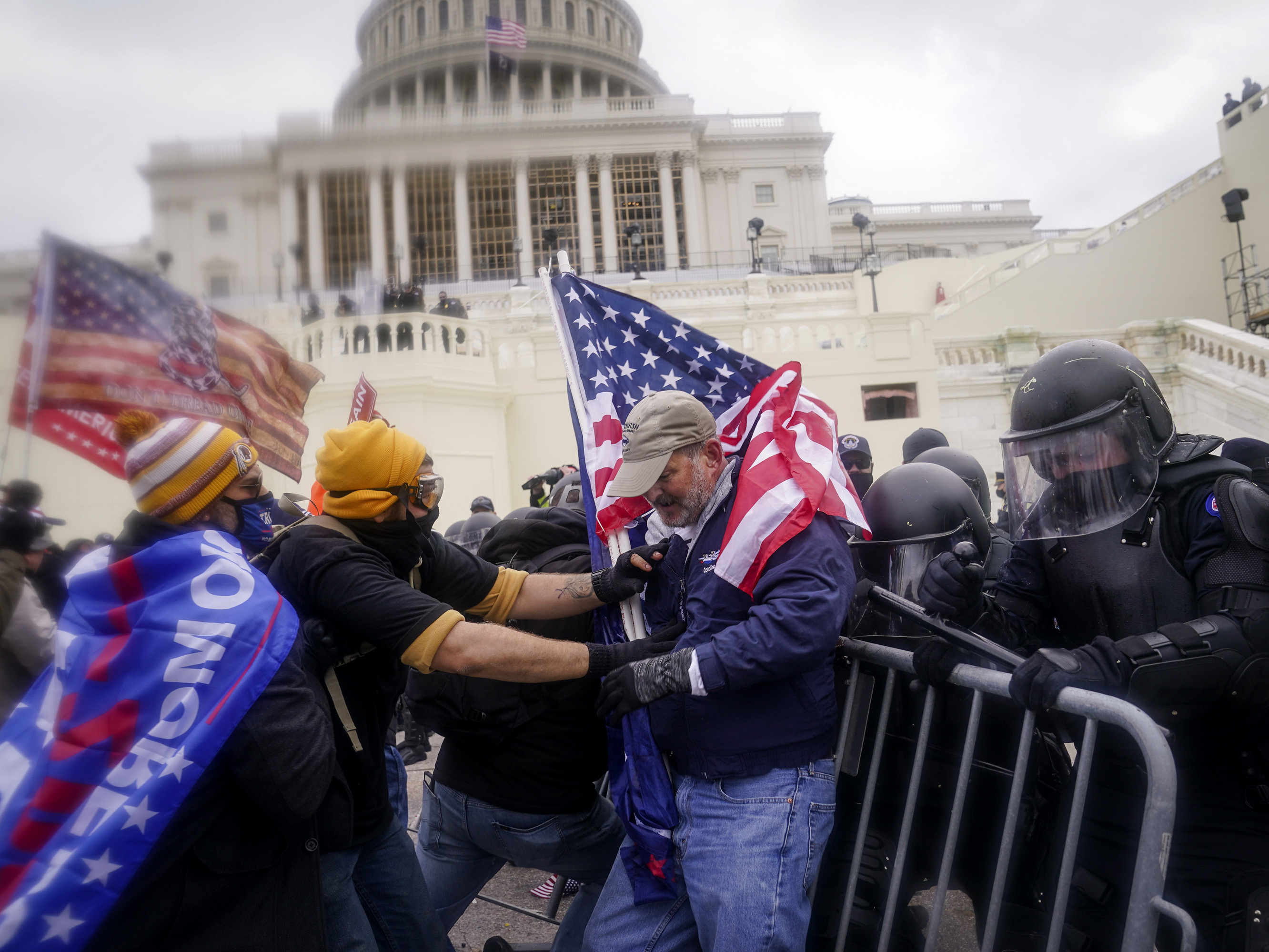 caption: Rioters try to break through a police barrier at the U.S. Capitol on Jan. 6.