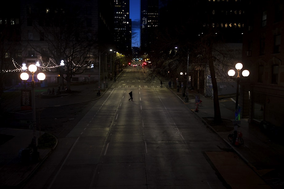 caption: A pedestrian crosses an empty 4th Avenue on Wednesday, March 25, 2020, in Seattle. On March 23, Gov. Jay Inslee announced he would sign a statewide order that requires everyone in the state to stay home in order to curb the spread of the virus. At the time, the Stay Home, Stay Healthy order was to last for two weeks and could be extended.