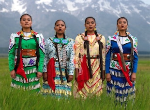 caption: From left, JoAnni Begay, Erin Tapahe, Dion Tapahe and Sunni Begay pose for "The Jingle Dress Project" creator and photographer Eugene Tapahe.