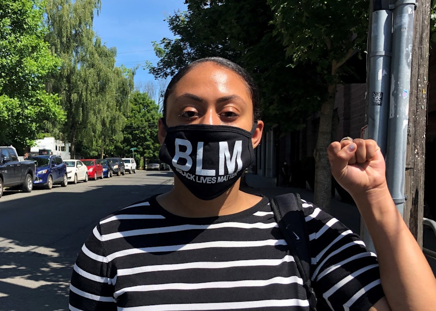 caption: Whole Foods employee Camille Tucker-Tolbert poses wearing the mask she was told was against company dress code. She says she and her coworkers are now facing disciplinary action as a result of wearing the masks at work on June 19 — the day of Juneteenth, a holiday commemorating the emancipation of enslaved people in the U.S. 