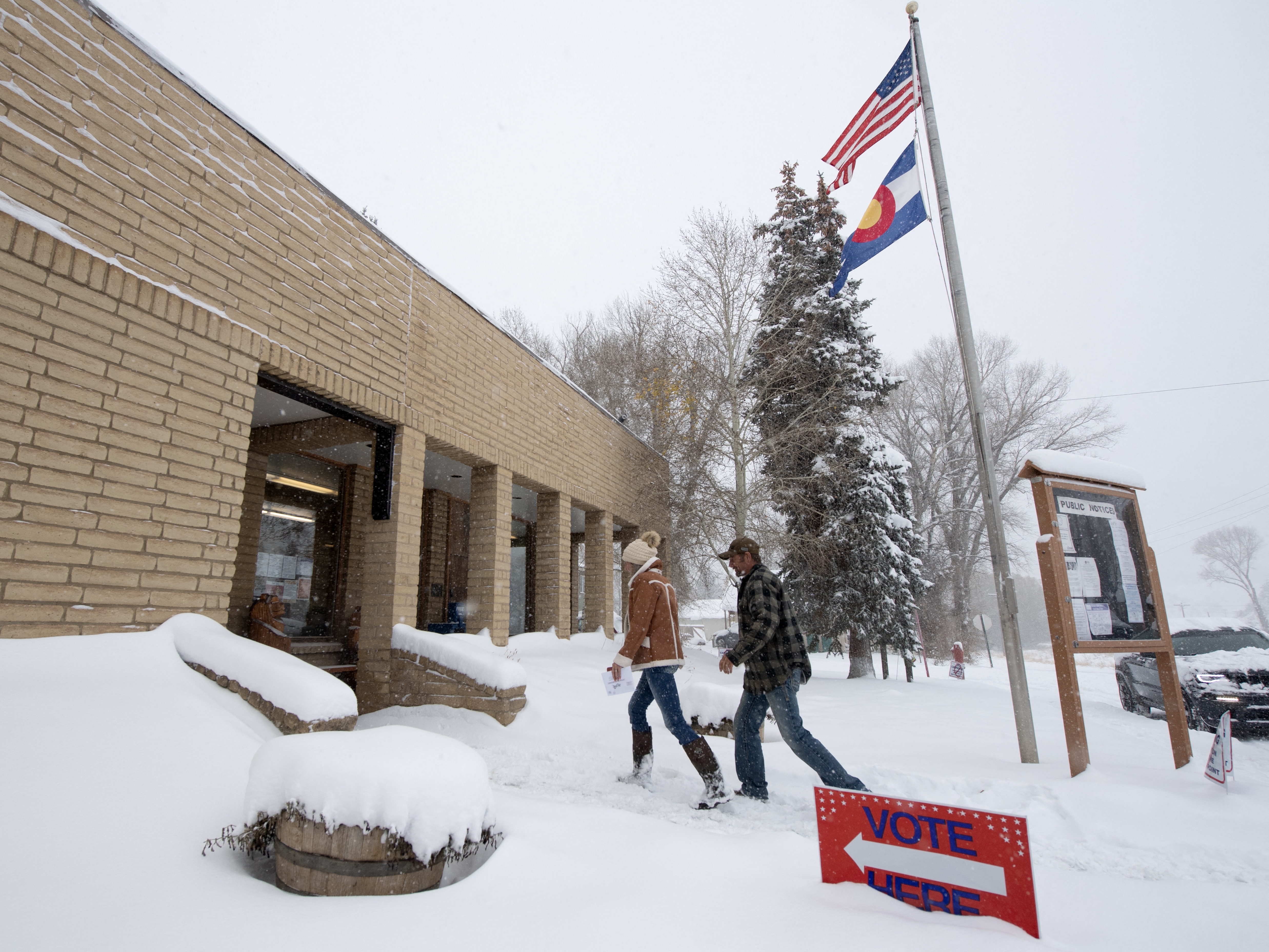 caption: Voters walk into the Oak Creek Town Hall to drop off their ballots on Nov. 5, 2024, in Oak Creek, Colo.