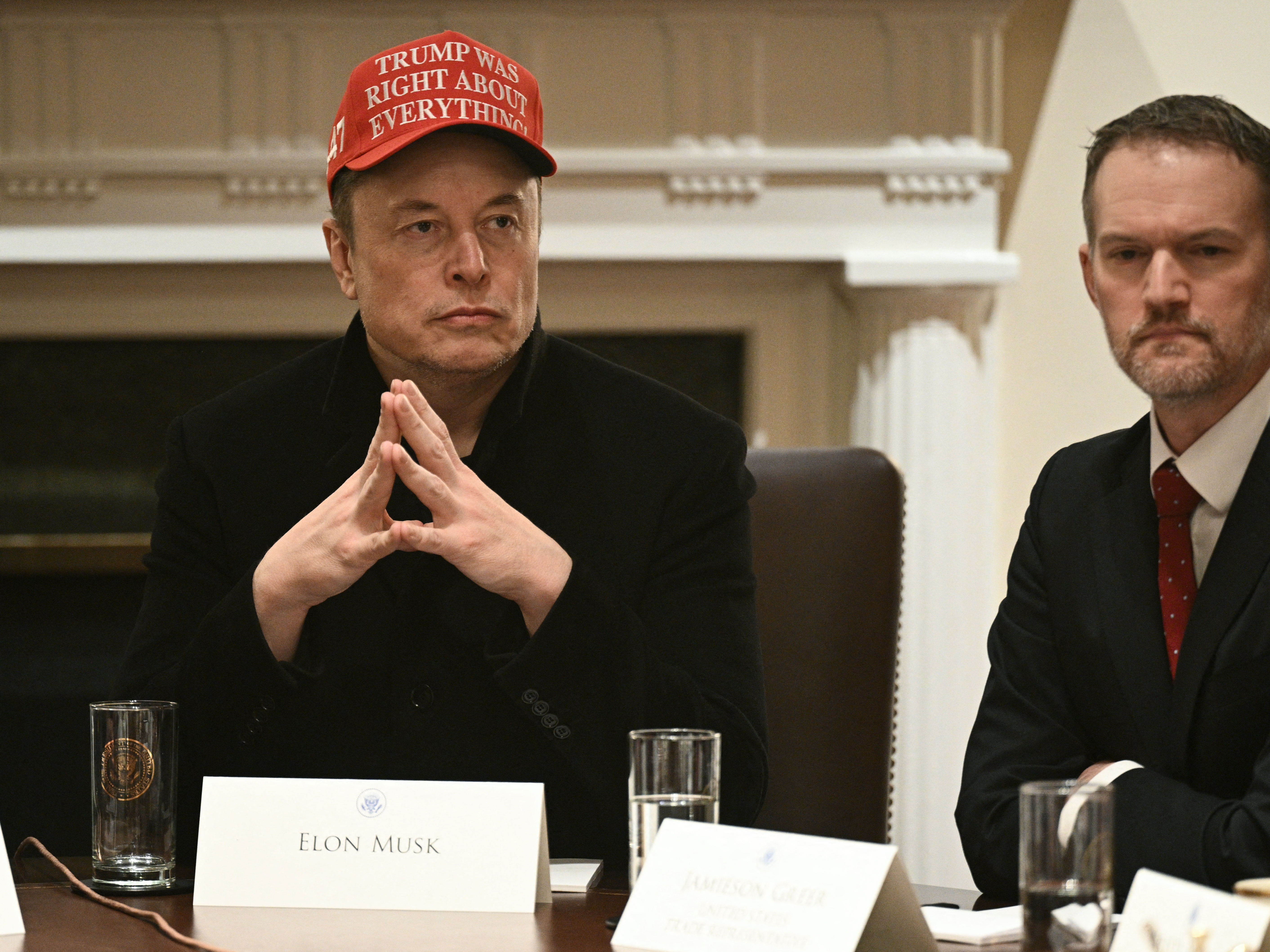 caption: Elon Musk and U.S. Trade Representative Jamieson Greer listen during a cabinet meeting in White House on March 24,.